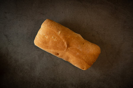 Fresh bread on dark background. Top view. Selective focus. Toned.
