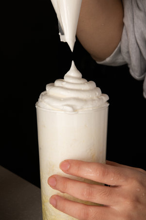 chocolate milkshake with whipped cream on a black background.の写真素材