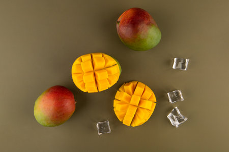 mango fruit with ice cubes on green background, top view.の写真素材