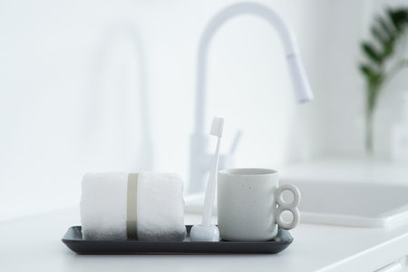 Toothbrush, toothpaste, towel and cup of coffee on white table in bathroomの写真素材
