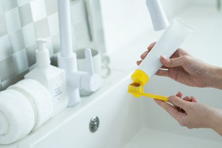 Woman cleaning teeth with toothbrush in bathroom. Hygiene concept.