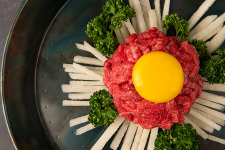 Raw beef tartare with egg yolk and parsley, top viewの写真素材