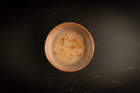 Top view of rice porridge in a bowl on black marble backgroundの写真素材