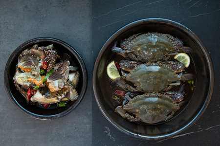 Steamed crab in black bowl with lemon and herbs on black background