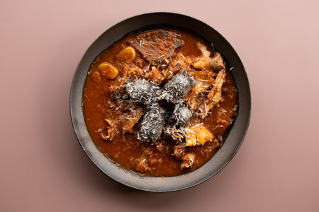 A bowl of lamb curry with coconut flakes and parmesan cheese