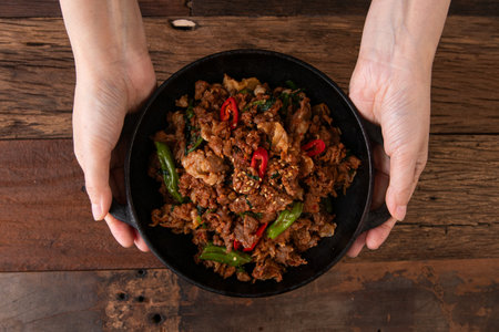stir-fried pork with chilli and basil in black bowlの写真素材