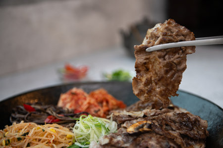 Beef steak on black plate with chopsticks, selective focus.の写真素材