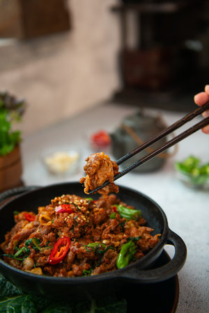 spicy stir-fried pork with basil and chilli in black bowlの写真素材
