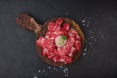 Raw beef sirloin with herbs and spices on black stone backgroundの写真素材