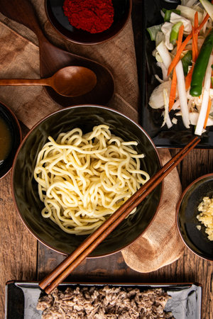Soba noodles with vegetables and meat in a bowl on wooden background