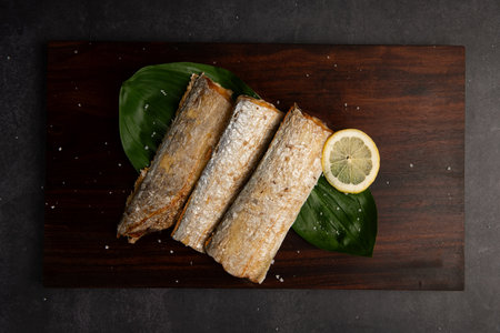 Fried mackerel with lemon on wooden board. Top view