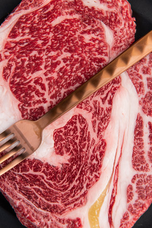 Raw wagyu sirloin beef steak on a black backgroundの写真素材