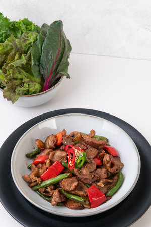 Stir-fried beef with sweet pepper and green peas on white backgroundの写真素材