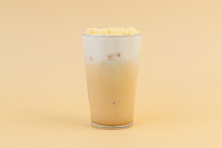milkshake with cornflakes in glass on yellow background.