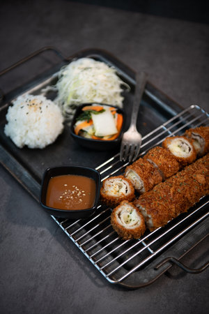 Fried pork cutlets with rice and vegetables on a metal trayの写真素材