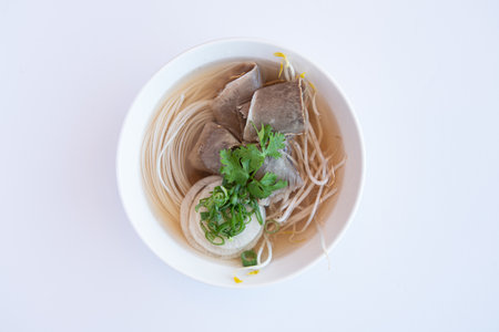 Vietnamese noodle soup with pork in bowl on white background