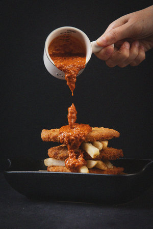 Crispy fried chicken nuggets with sauce on a black background
