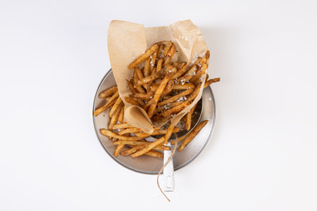 French fries in a paper bag on a white background, top view