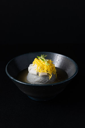 Noodles in a blue bowl on a black backgroundの写真素材