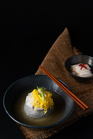 dumpling soup in a bowl on black background