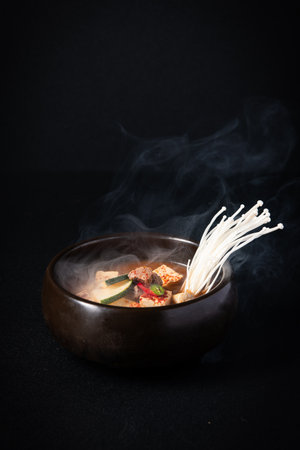 Korean food, beef and mushroom soup in a bowl on black background