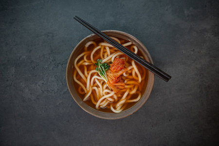 Japanese udon noodles in a bowl with chopsticks on dark backgroundの写真素材
