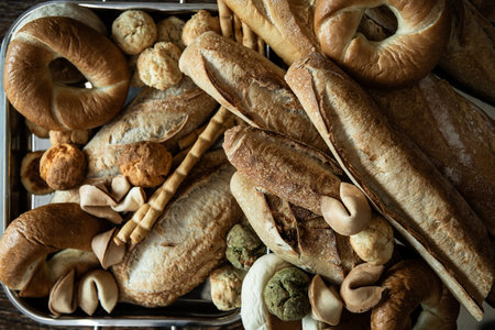 Assortment of bread in a basket on rustic wooden background.