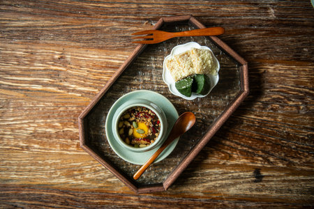 Sweet and sour soup in a wooden tray on a wooden backgroundの写真素材