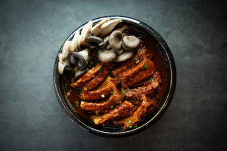 Pork ribs with oyster mushrooms in bowl on dark background.の写真素材
