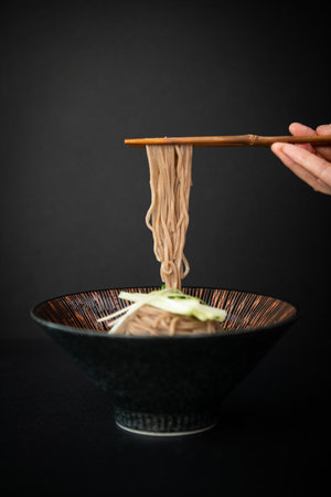 Japanese noodles in a bowl with chopsticks on a black backgroundの写真素材