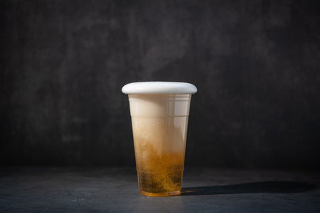 Plastic cup of a beverage on a dark background. Copy space.の写真素材