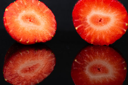 Strawberries on a black background with reflection. Close up.