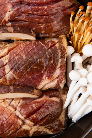 Beef and mushrooms on a black plate, close-up.の写真素材