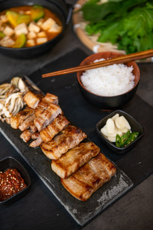 Grilled pork belly served with miso soup on black slate plateの写真素材