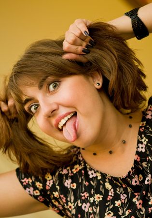 Portrait of young beautiful woman putting out her tongueの写真素材