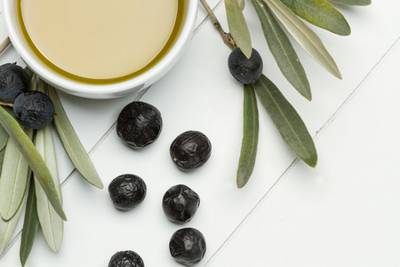Olives and a bowl with olive oilの写真素材