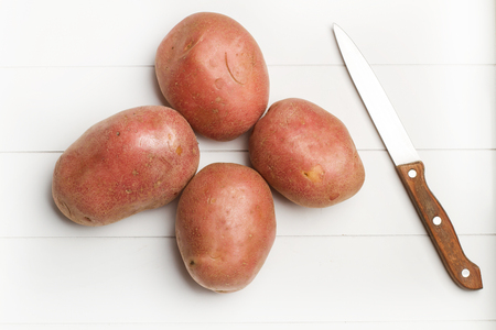 Red potatoes and a knifeの写真素材