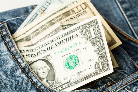 Dollar bills in a blue pocket jeans