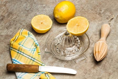 Lemons, a wooden squeezer and a glass squeezerの写真素材