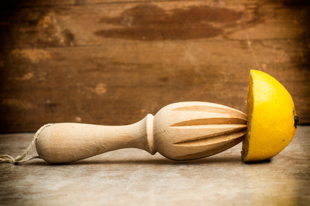 Half lemon and a wooden squeezerの写真素材
