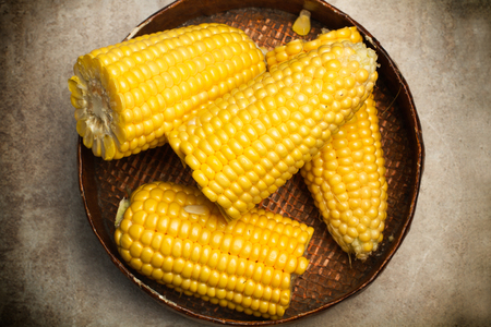 Pieces of corns on a wooden plateの写真素材