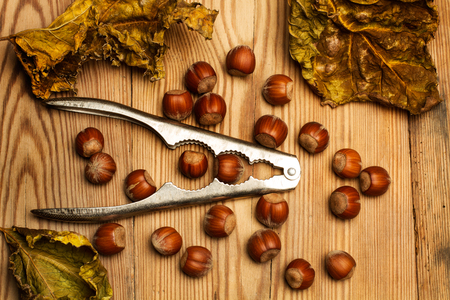 Almonds and nut cracker on a wooden tableの写真素材