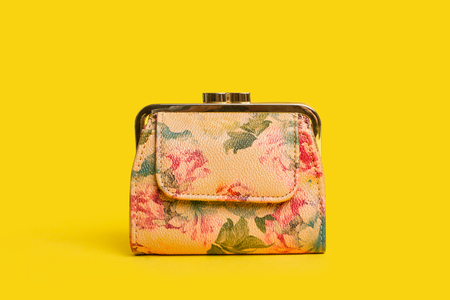 A floral coin purse on a yellow background