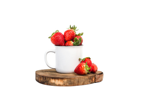 Strawberries in a mug on a wooden board