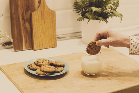 Man with cookies with chocolate chips and a glass of milkの写真素材