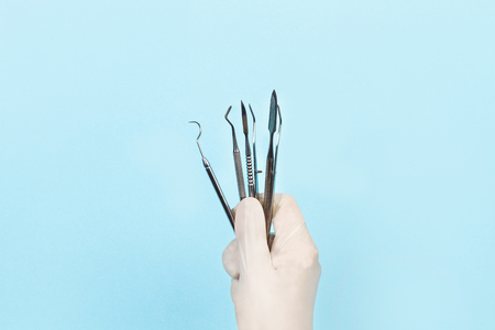 Dental instruments in a dentist's hand with medical glovesの写真素材
