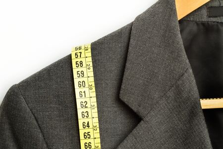 Yellow measuring tape on a gray suitの写真素材