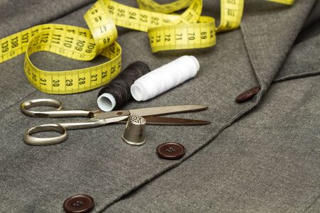 Scissors, thimble and other tools on a gray suit