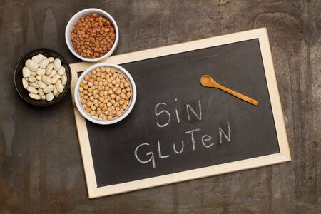 Beans, lentils and chickpeas in bowls on a blackboardの写真素材