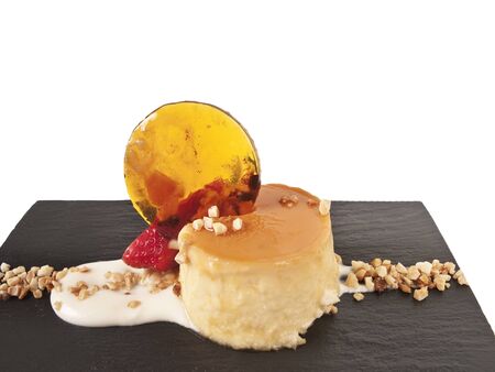 Vanilla flan with toppings on a black slab